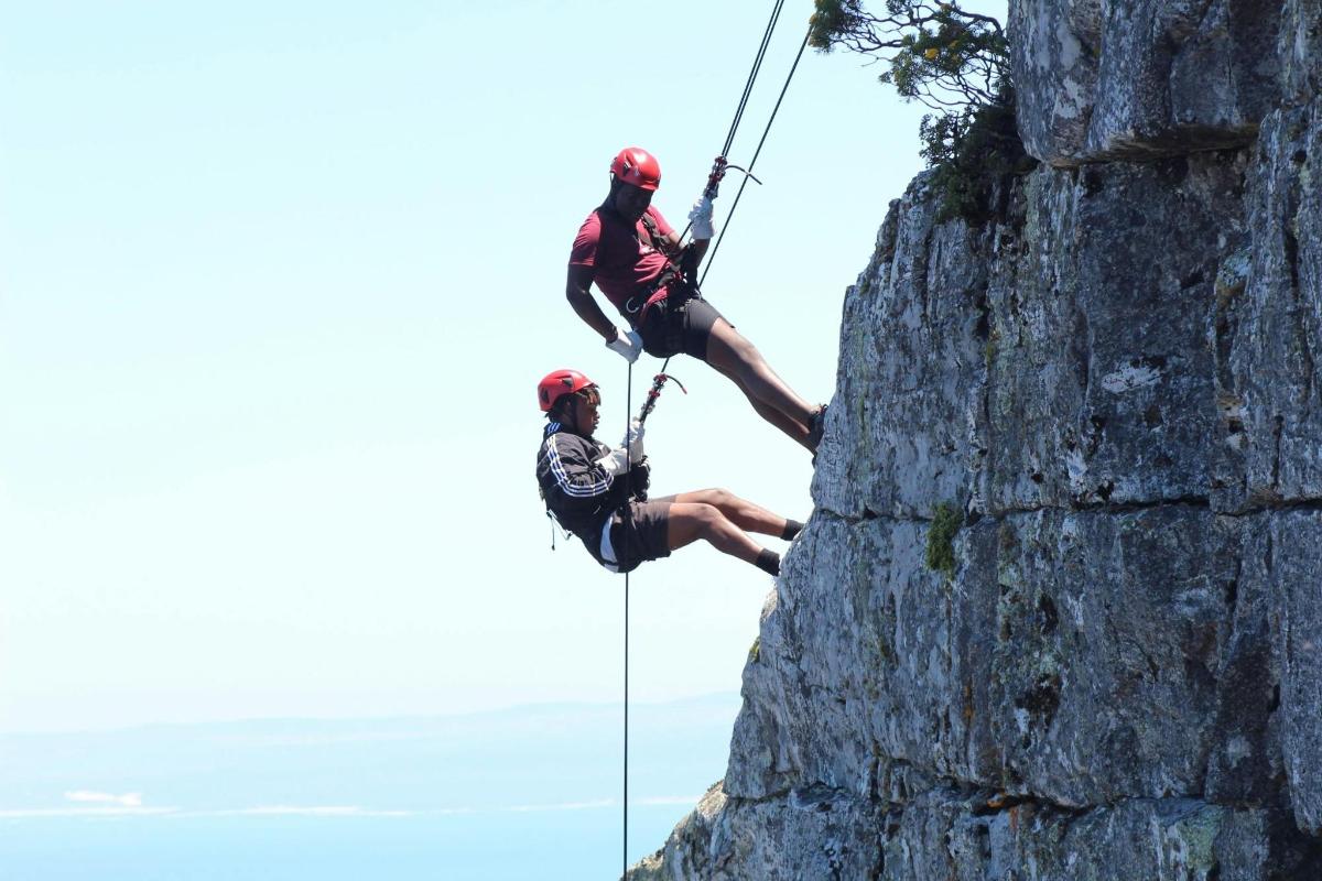 due persone che si calano in corda doppia da una parete rocciosa