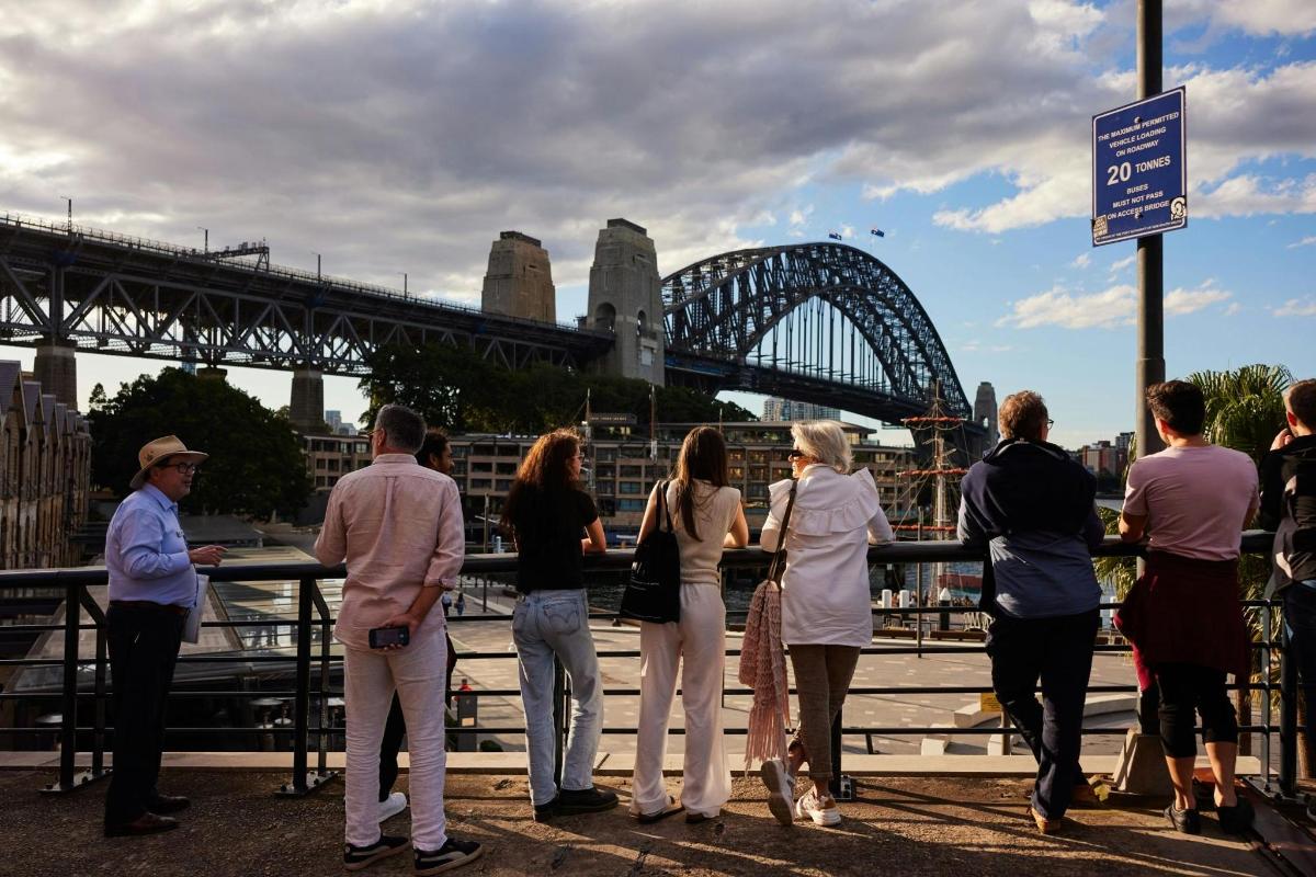 un grup de persones dempeus davant d'un pont