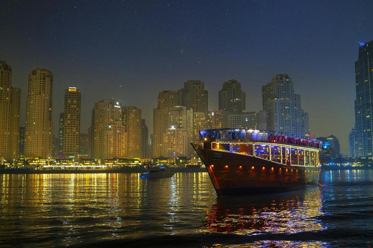 قارب في الماء مع مدينة في الليل