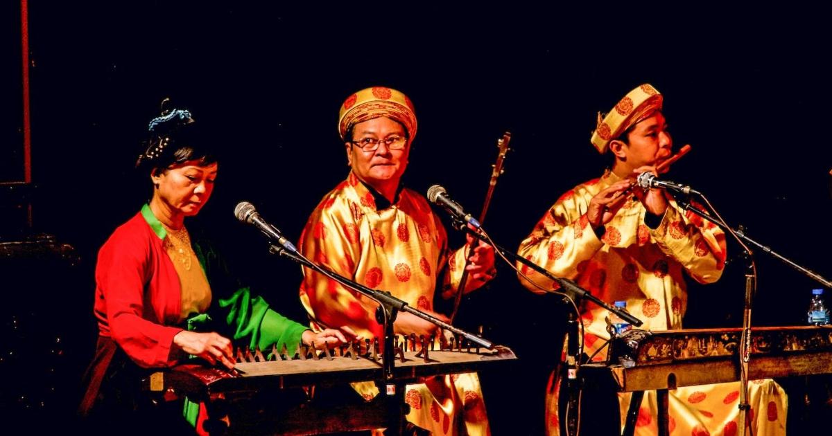 a group of three people playing music on a keyboard