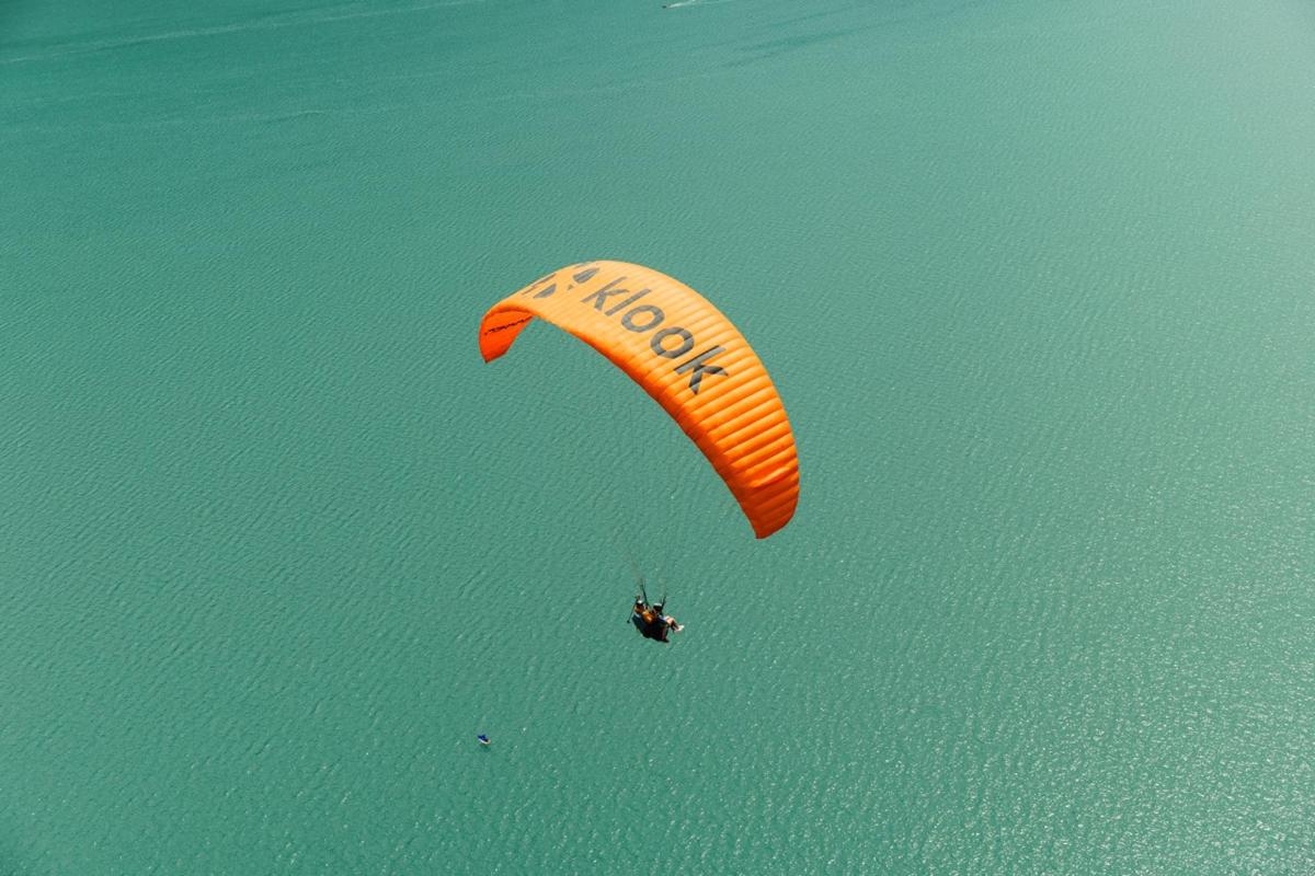 una persona montando una cometa en el aire sobre el agua