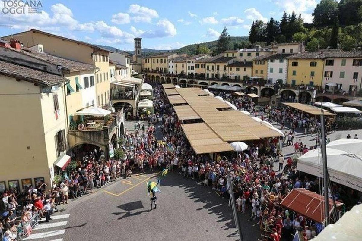 una folla di persone che guardano una parata in una città