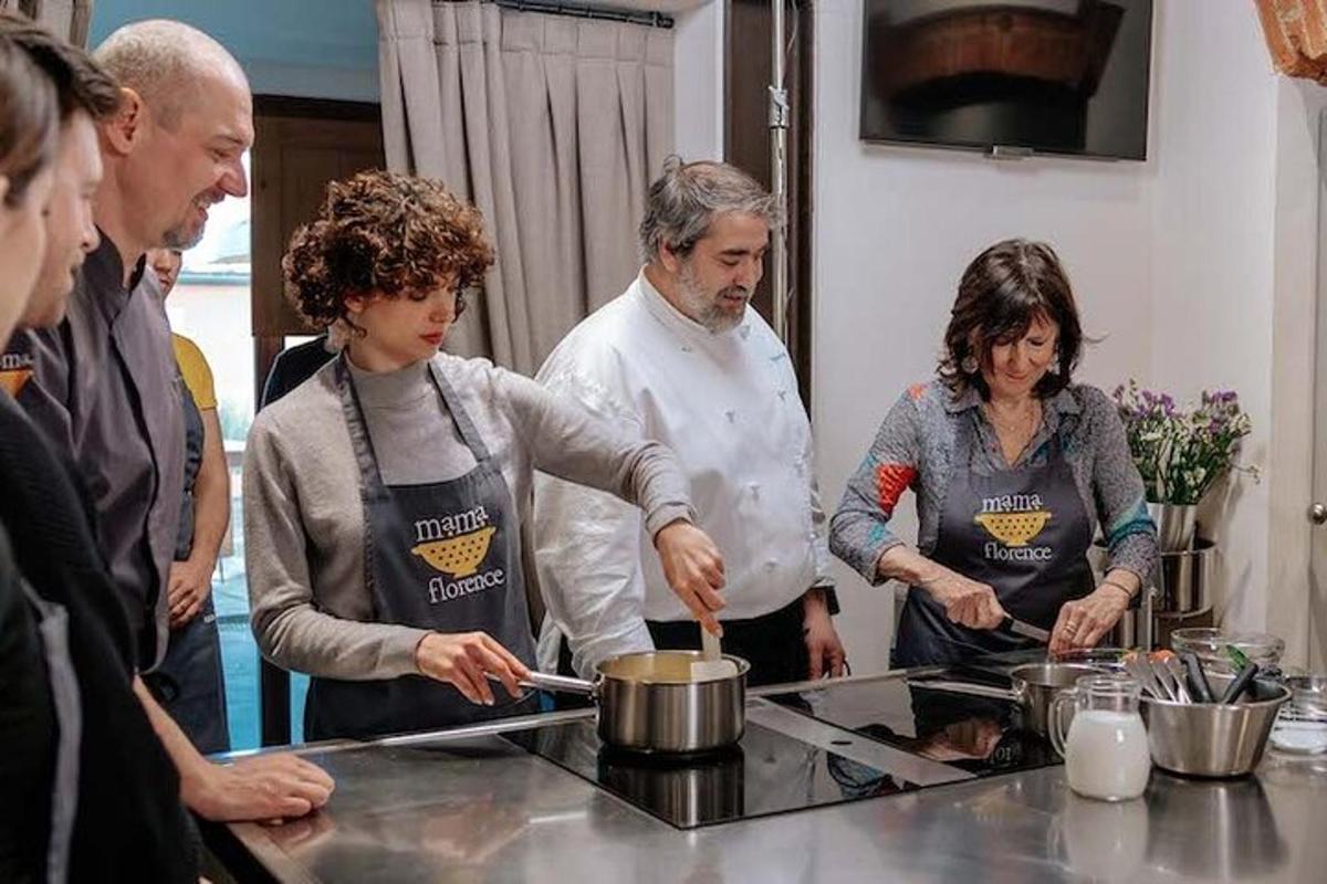 група људи стоји у кухињи и припрема храну