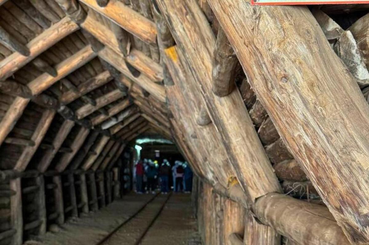 a tunnel in a wooden building with people walking through it