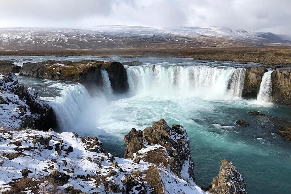 una cascada en medio de un río con nieve