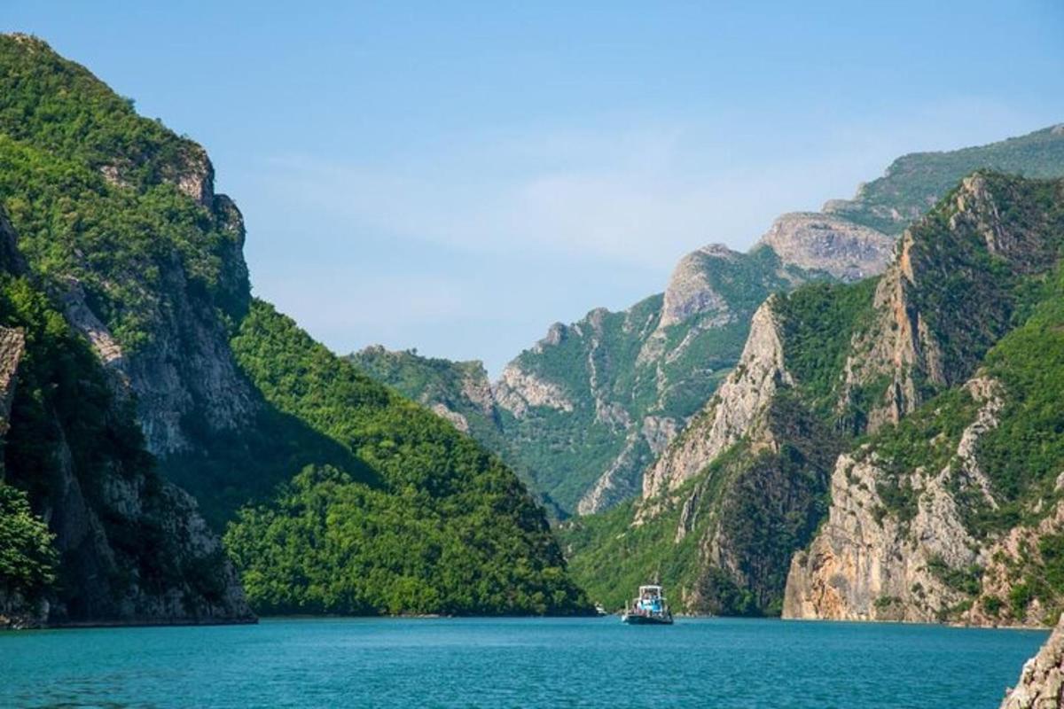 un vaixell en una gran massa d'aigua amb muntanyes