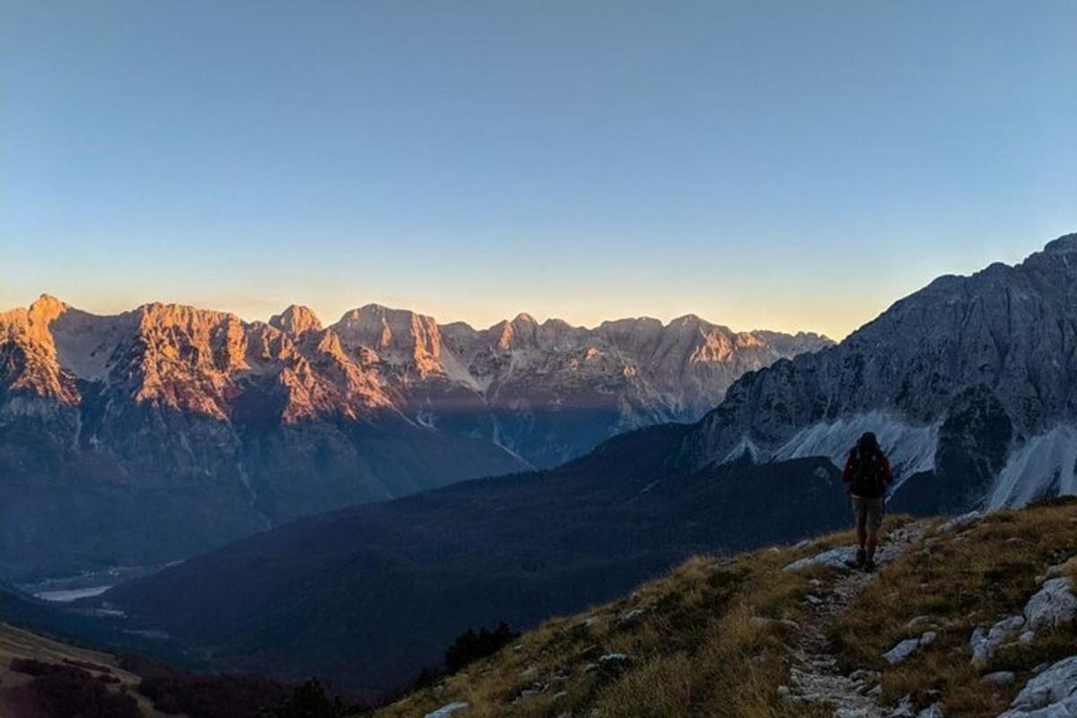 una persona que està dreta al vessant d'una muntanya