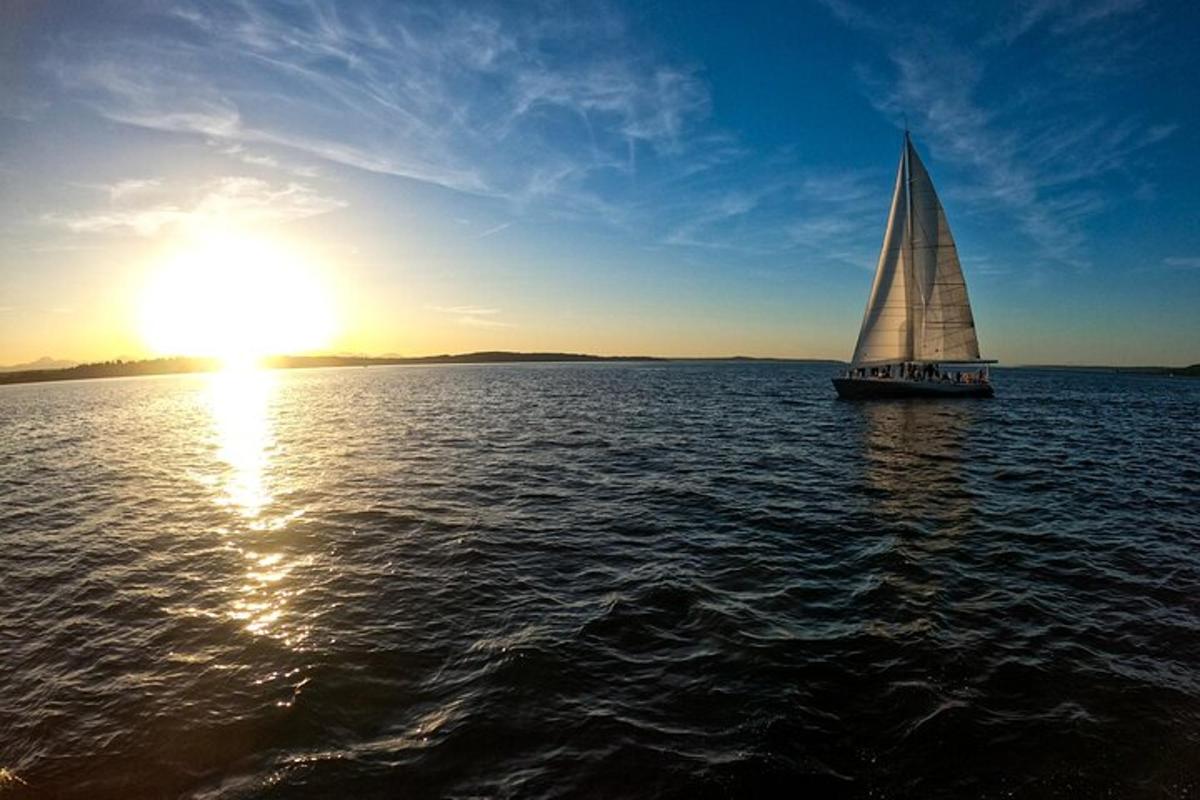 um veleiro na água com o pôr do sol