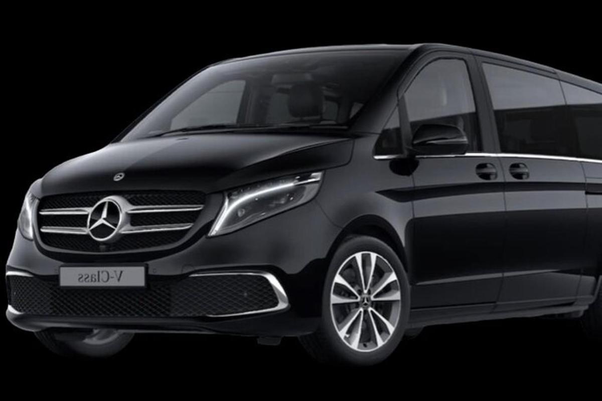 a gray mercedes benz minivan in a black background