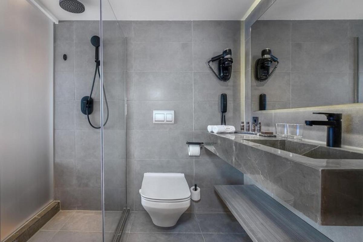 ein Badezimmer mit Dusche, Toilette und Waschbecken