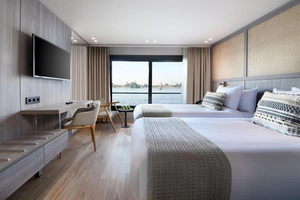 et hotellrom med to senger, et skrivebord og en TV