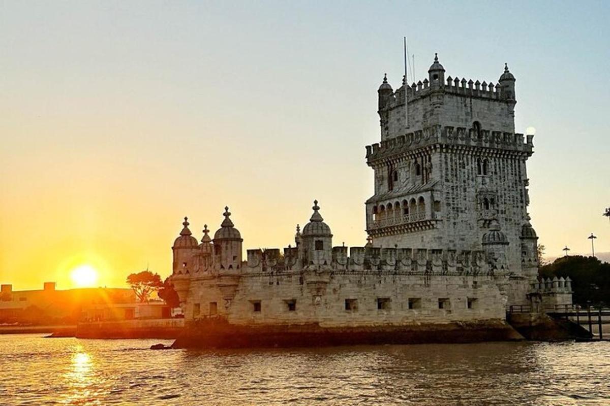 Un castillo en el agua con la puesta de sol al fondo