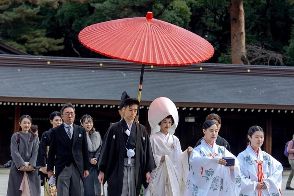 un gruppo di persone in kimono che tengono un ombrello rosso