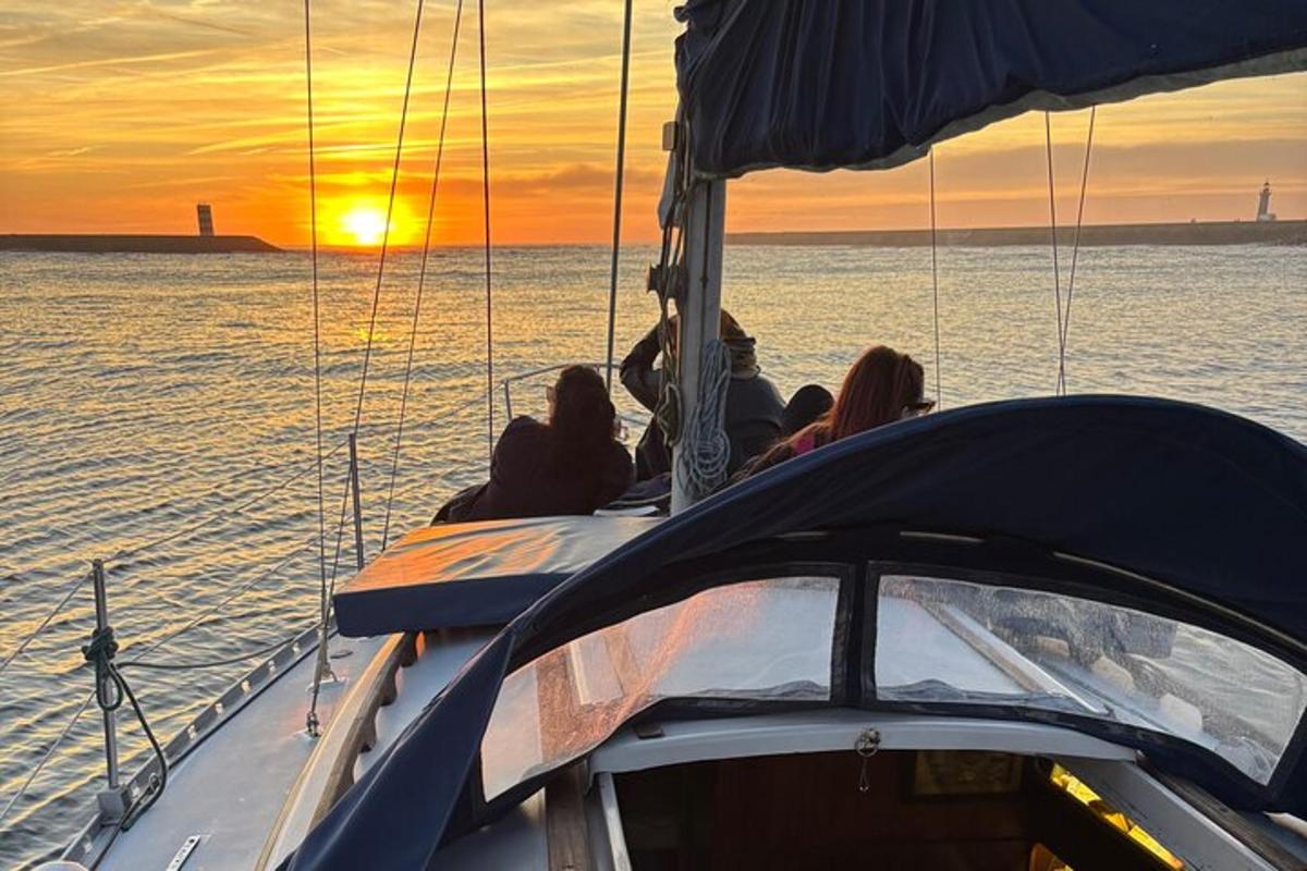 a group of people sitting on a boat at sunset