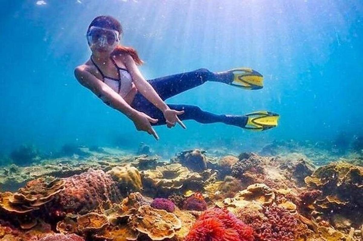 žena plave ve vodě nad útesem