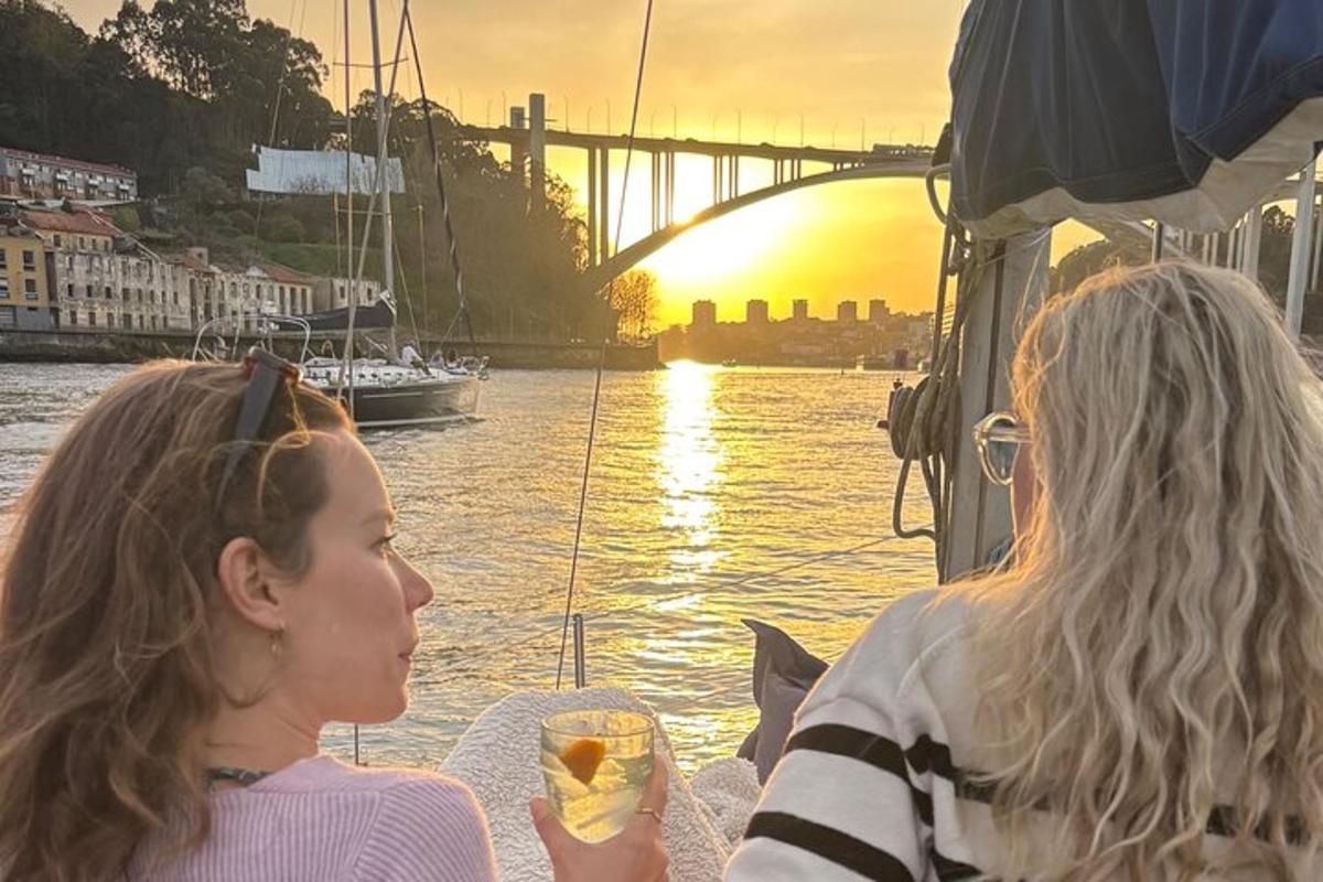 two women on a boat in the water at sunset