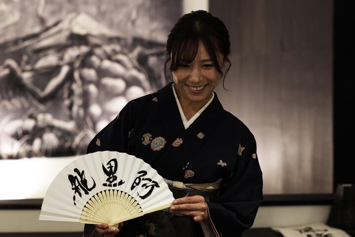 a woman in a kimono holding a fan