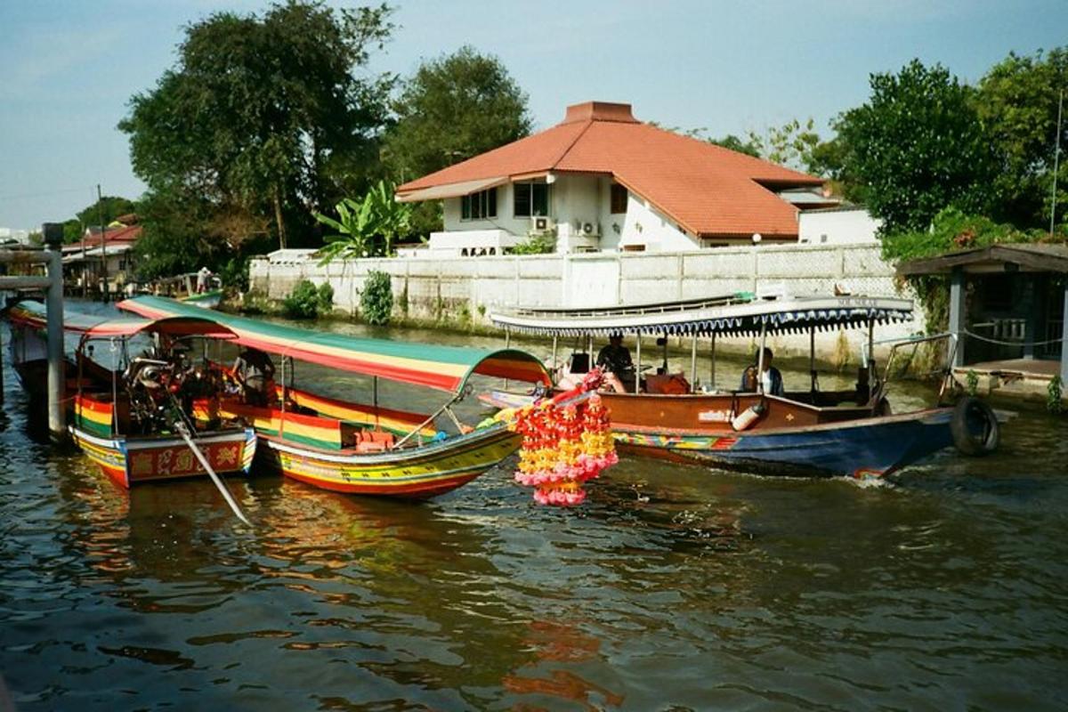 Tři lodě kotví ve vodě poblíž domu