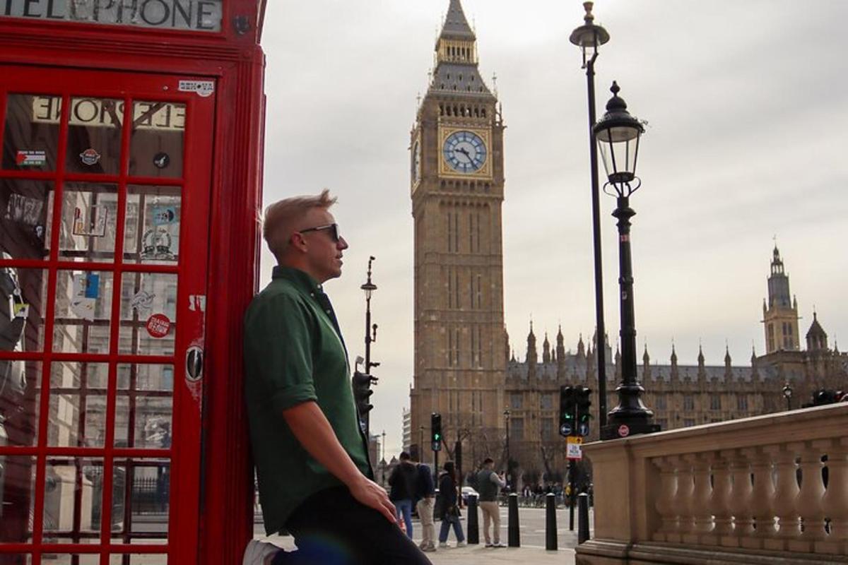 một người đàn ông đứng cạnh một buồng điện thoại trước tháp đồng hồ Big Ben