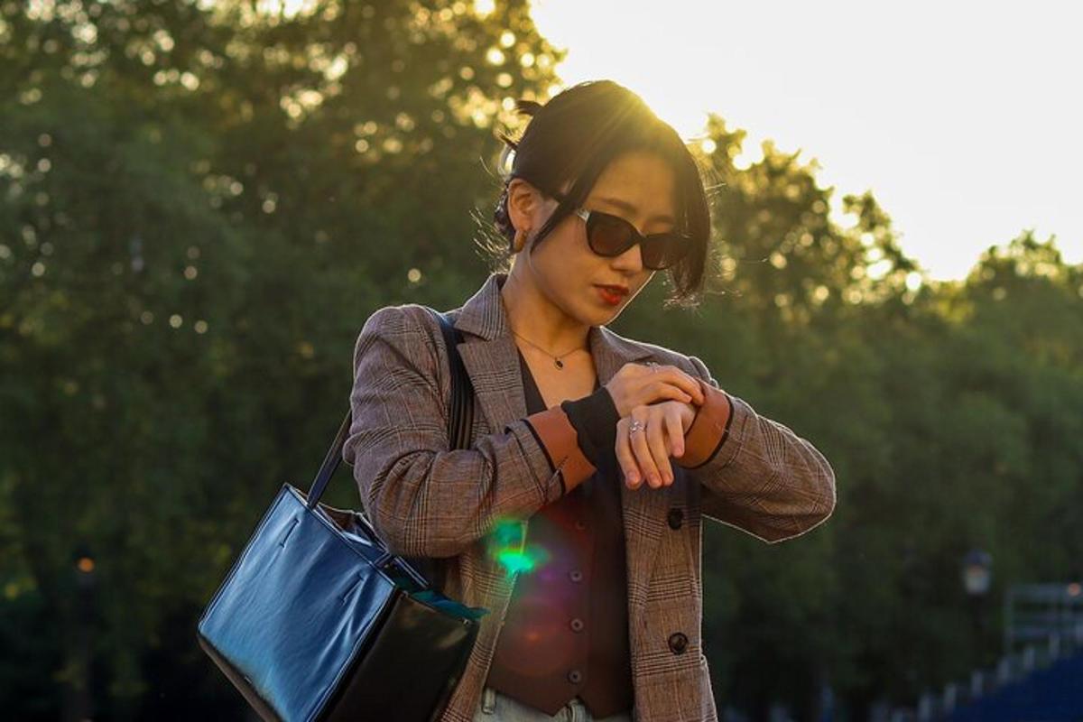 uma mulher usando óculos de sol está olhando para o relógio