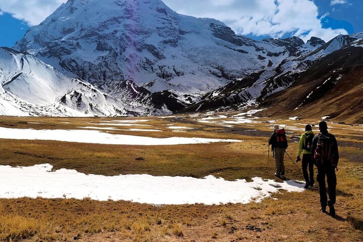 un gruppo di persone che camminano davanti a una montagna