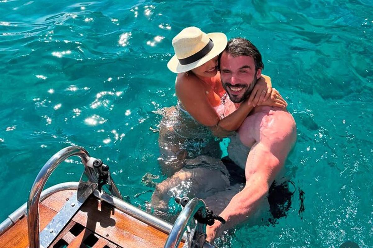 un uomo che tiene in braccio una donna su una barca in acqua