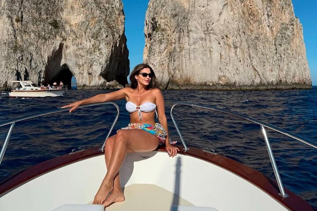 una donna in bikini seduta sulla parte anteriore di una barca