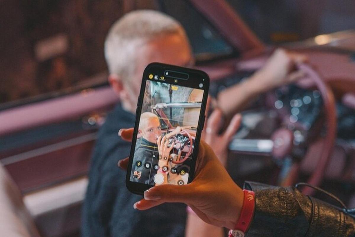 oseba, ki drži mobilni telefon, da bi fotografirala