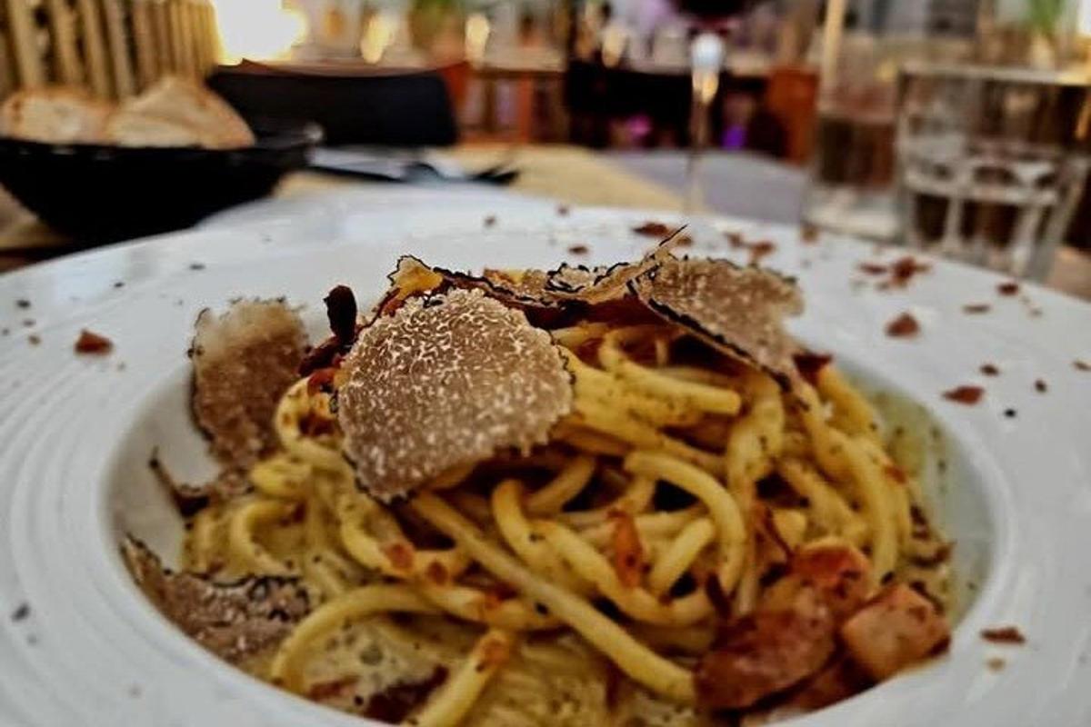 en hvid tallerken pasta med en sandwich ovenpå