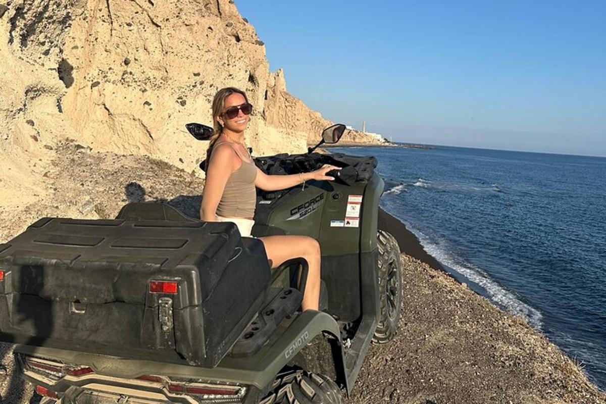 Una mujer sentada en la parte trasera de un vehículo todo terreno junto al océano.