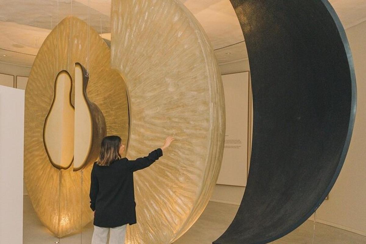 a woman is pointing at a sculpture in a museum