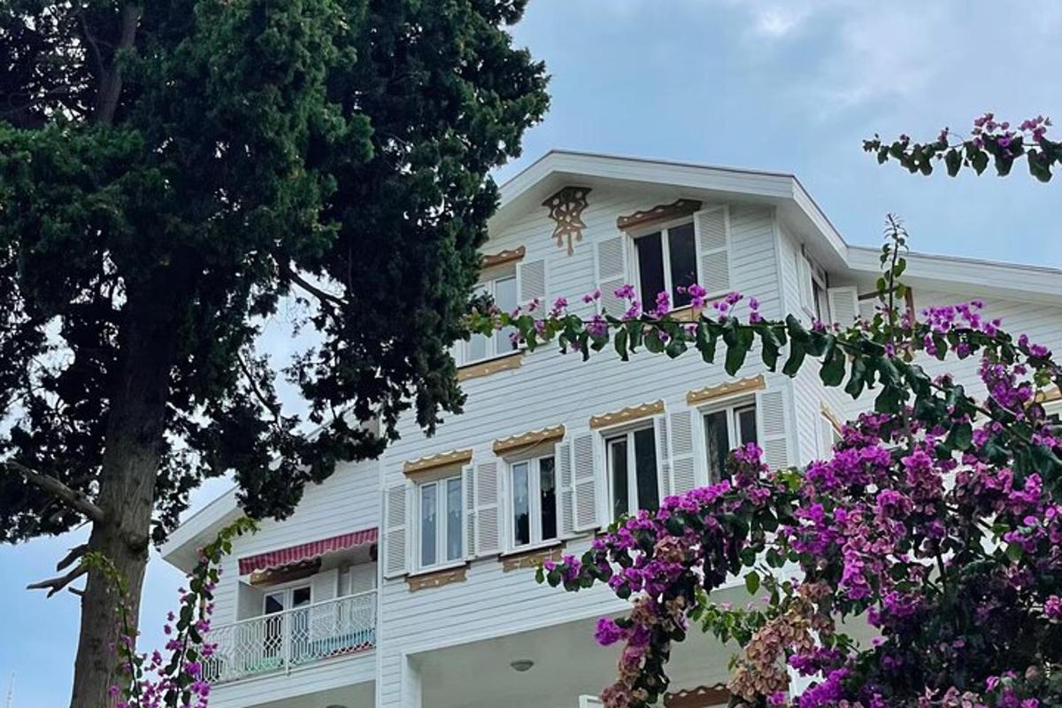 a white house with purple flowers in front of it