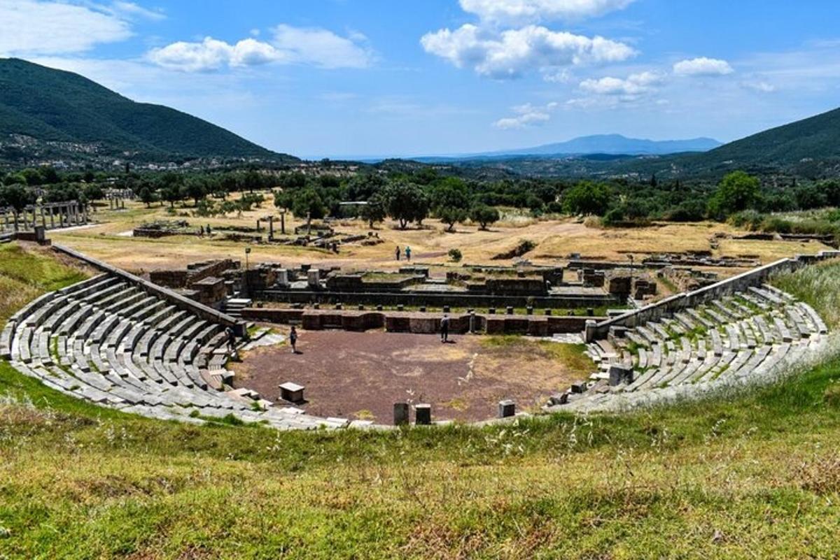 um anfiteatro em um campo com montanhas ao fundo