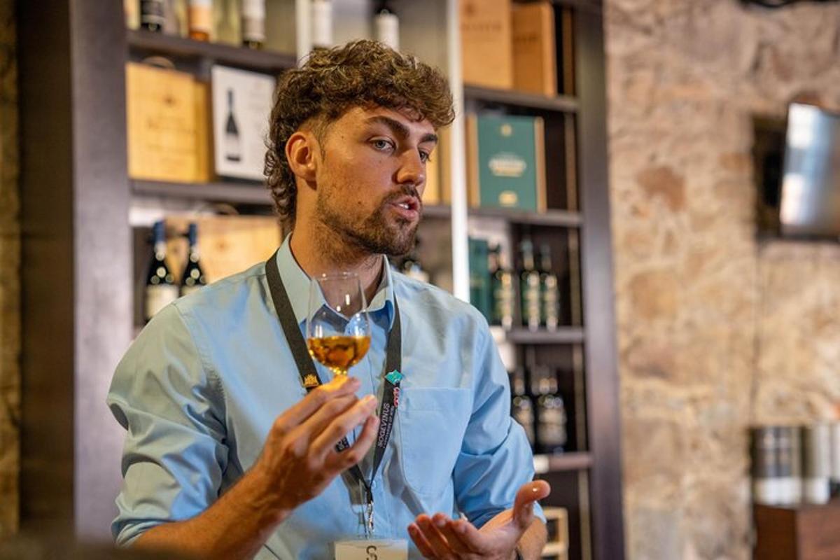 un uomo in piedi in un bar con in mano un bicchiere di vino