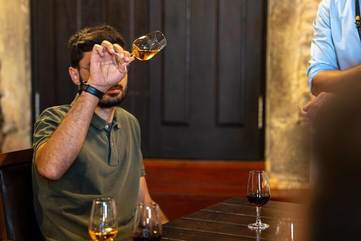 un uomo seduto a un tavolo che beve un bicchiere di vino