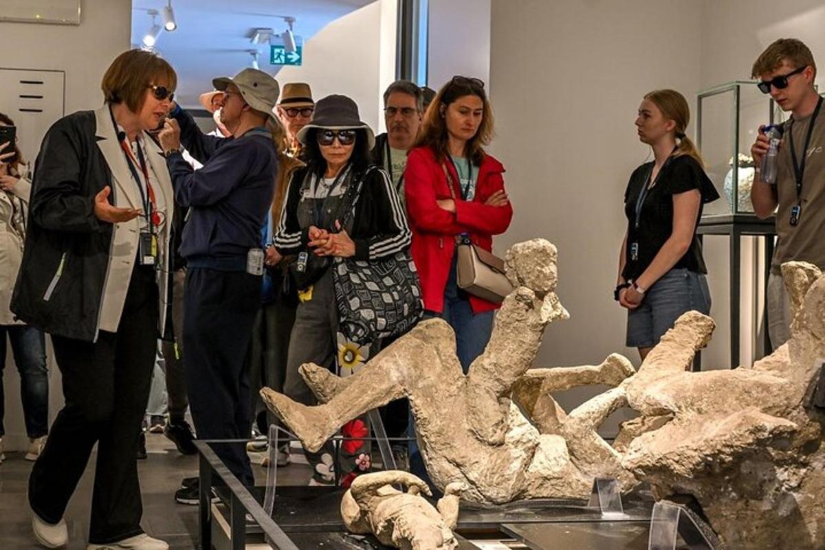 eine Gruppe von Menschen, die neben einer Statue stehen
