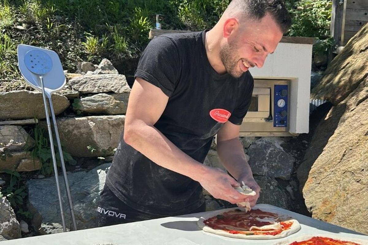 un uomo sta preparando una pizza su un tavolo