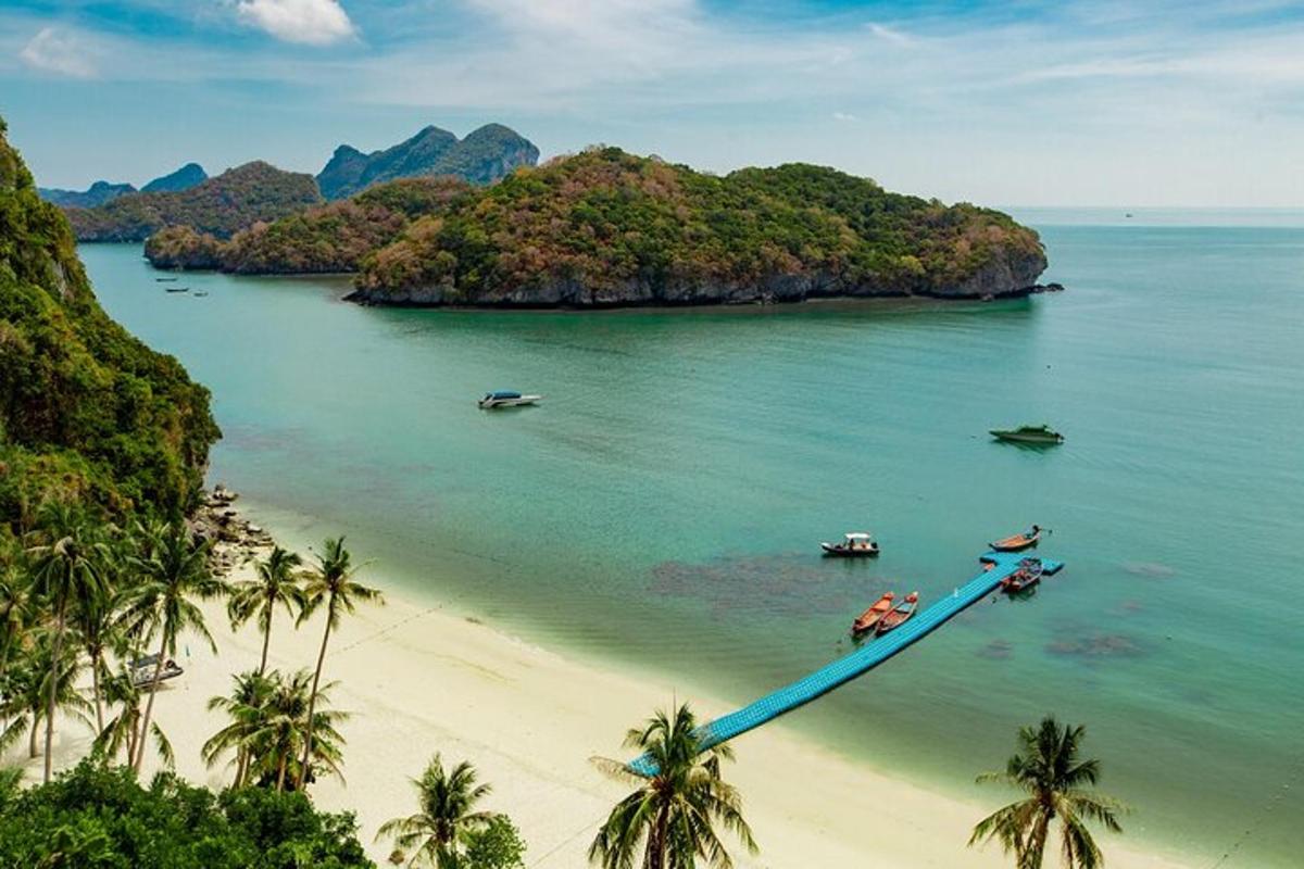sebuah pulau dengan bot di dalam air di sebelah pantai