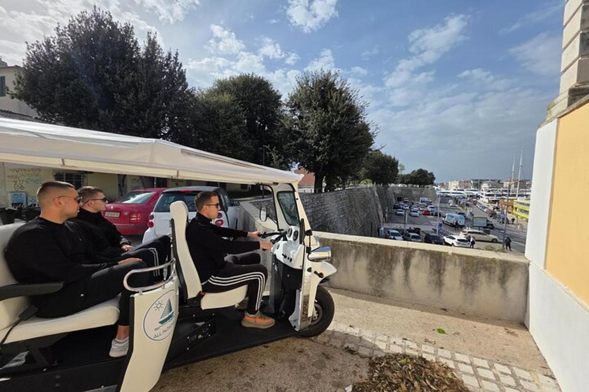 egy csoport férfi golfkocsiban utazik