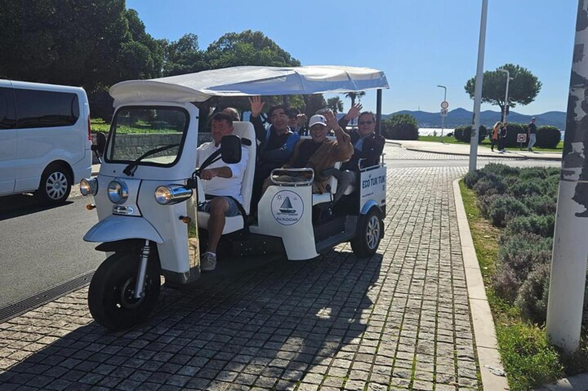 skupina lidí jedoucích v golfovém vozíku