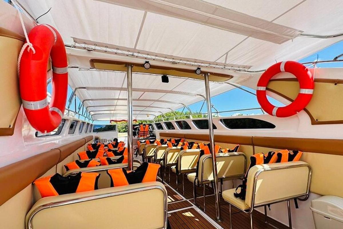 a boat with orange chairs and a red life preserver