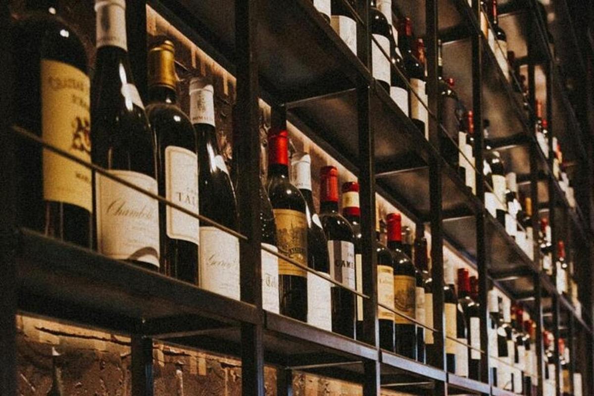 un mucchio di bottiglie di vino appoggiate sugli scaffali