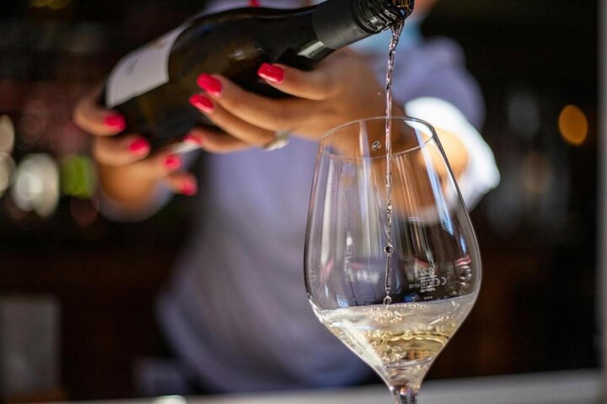 una donna che versa il vino in un bicchiere da vino