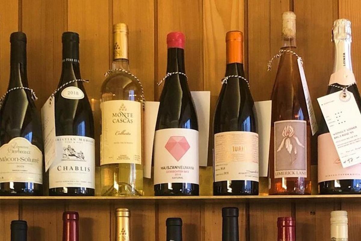 un mucchio di bottiglie di vino appoggiate su uno scaffale