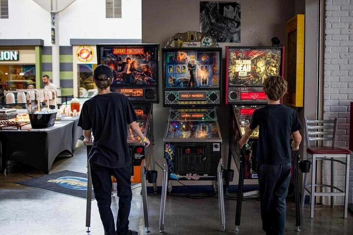 two men playing a video game in front of machines