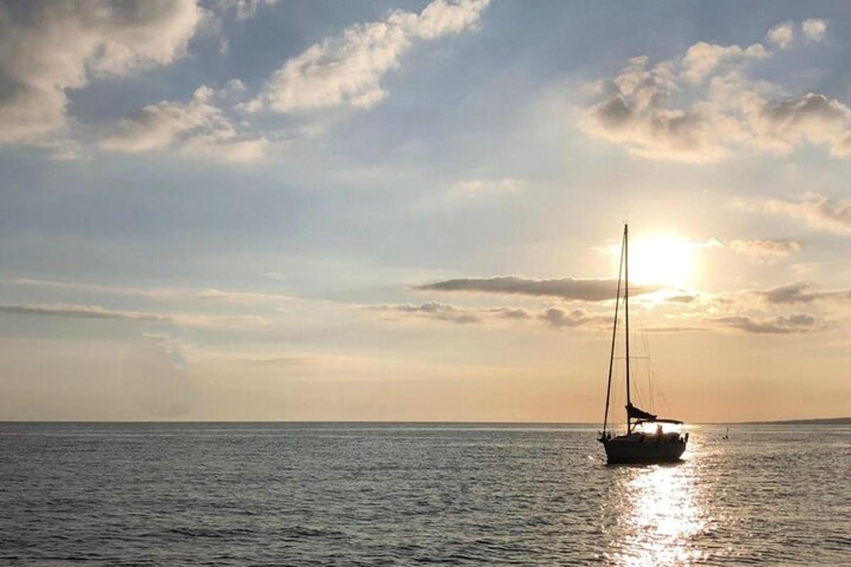 jadrnica v oceanu s sončnim zahodom