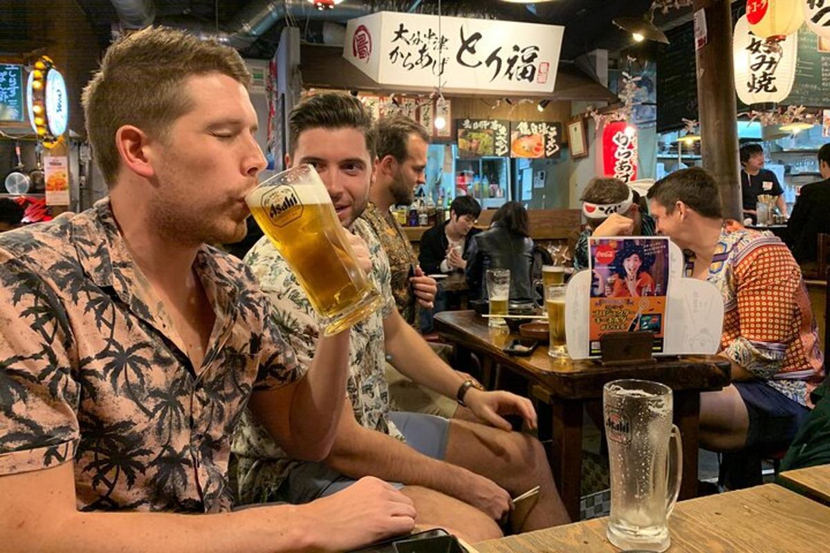 skupina mužů sedících u baru a pijících pivo