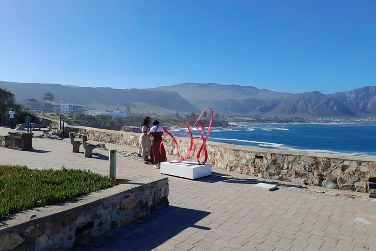 due persone in piedi accanto a una scultura sulla spiaggia