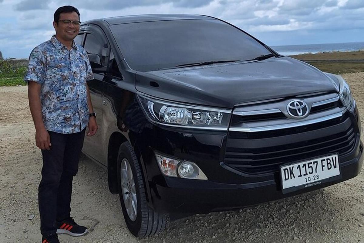 um homem está parado na frente de uma caminhonete Toyota