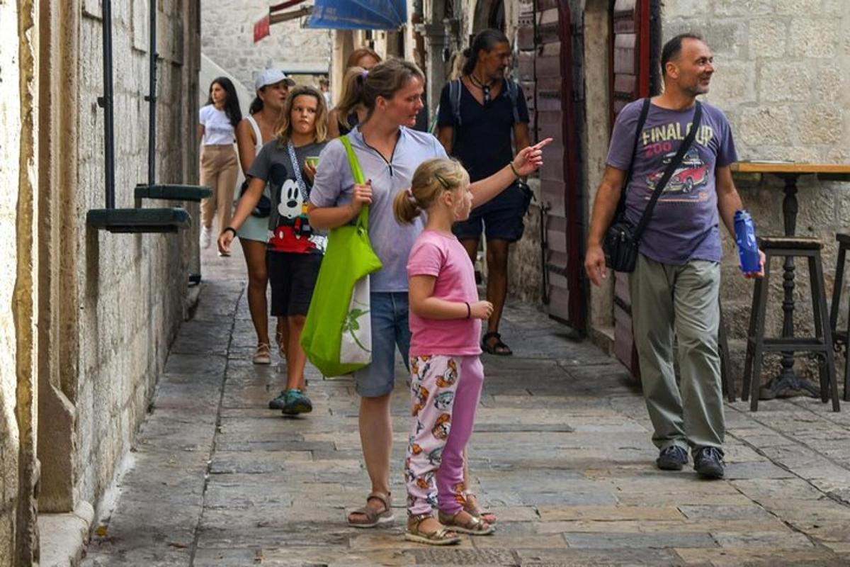 a woman and a little girl walking down a street